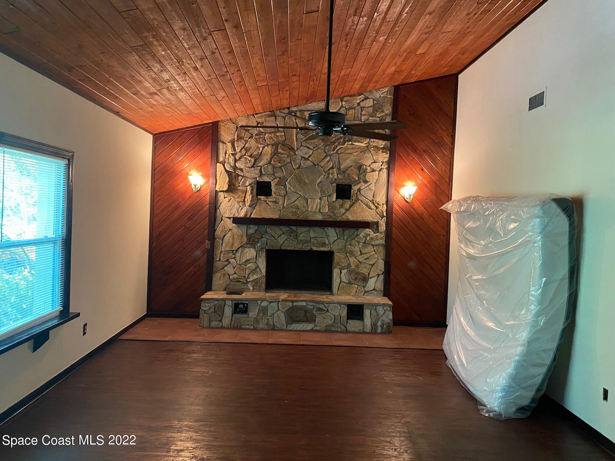 4985 Ranchland Road Melbourne, FL 32934 - Photo 3 of 13 a room with fireplace and wooden floor