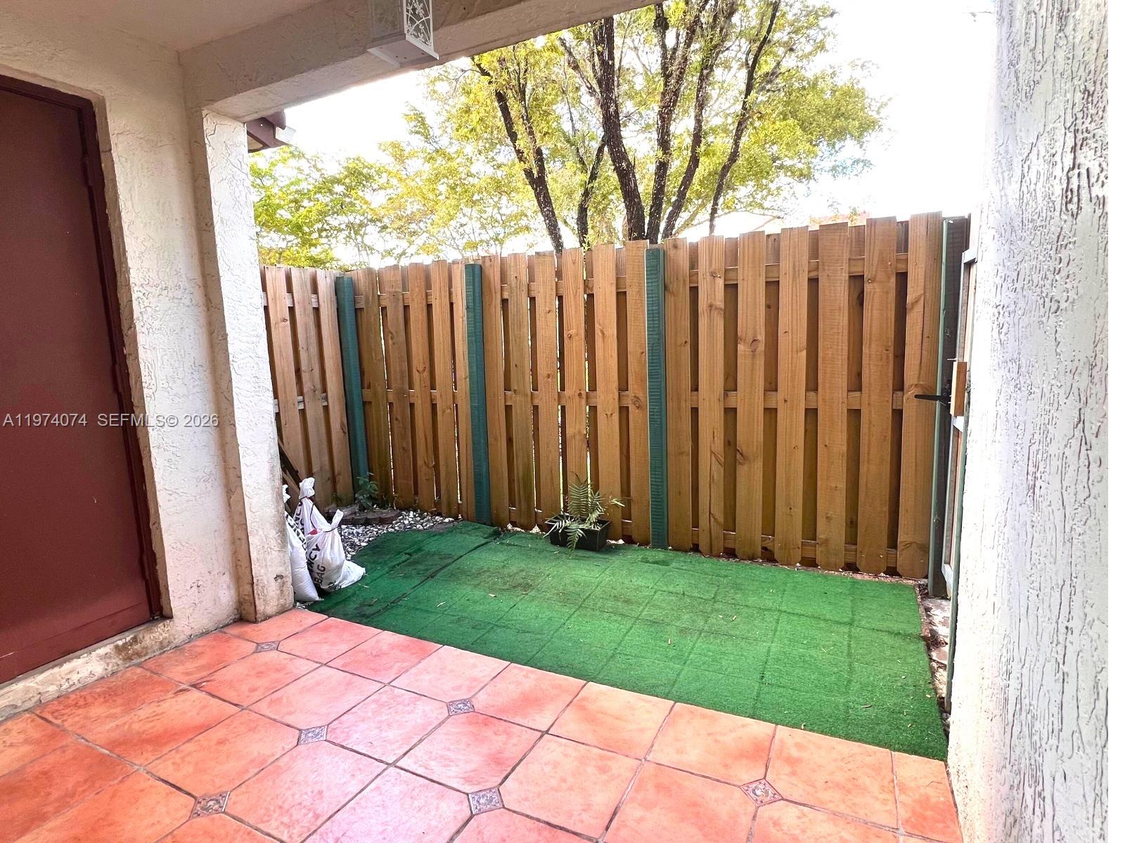 8911 Southwest 123rd Court, Unit 101 Miami, FL 33186 - Photo 13 of 15 a view of backyard with potted plants and wooden fence