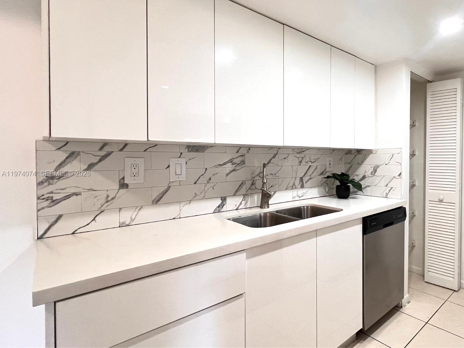 8911 Southwest 123rd Court, Unit 101 Miami, FL 33186 - Photo 5 of 15 a kitchen with a sink and cabinets