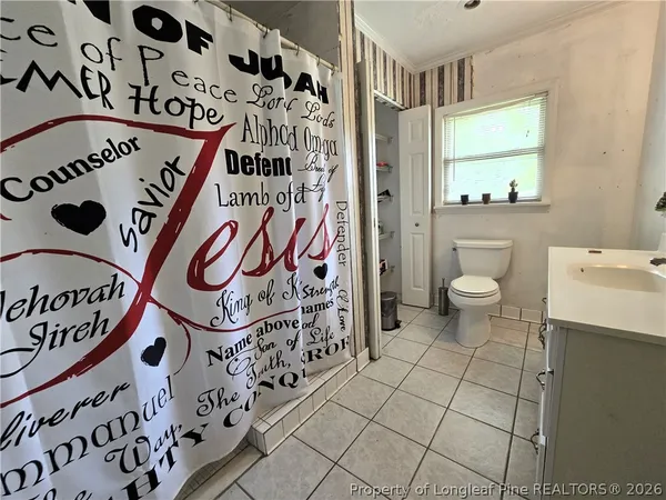a bathroom with a toilet and a shower curtain