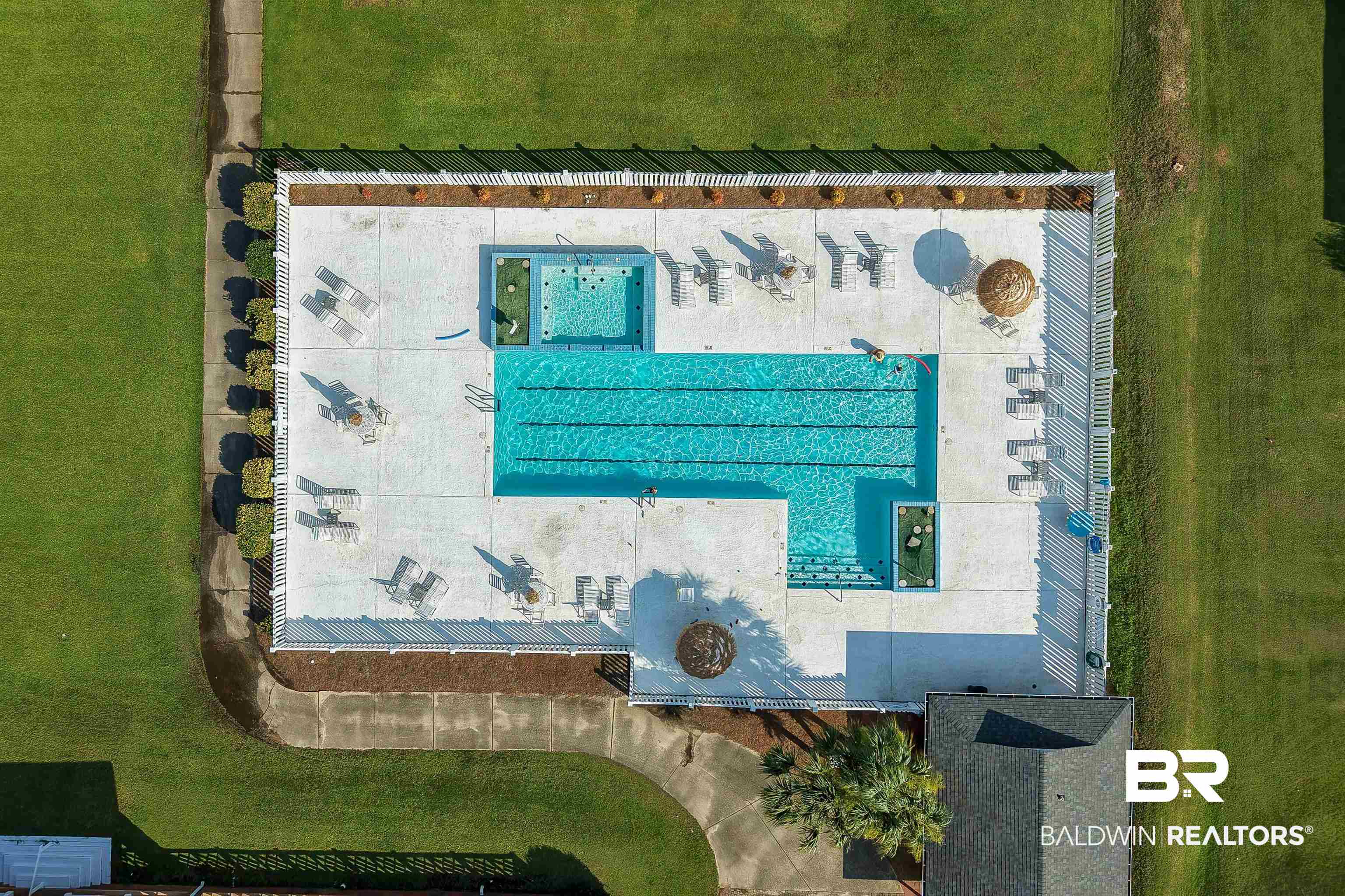 22685 County Road 12 Foley, AL 36535 - Photo 87 of 89 Community pool with lap lanes and a separate spa, surrounded by a concrete deck