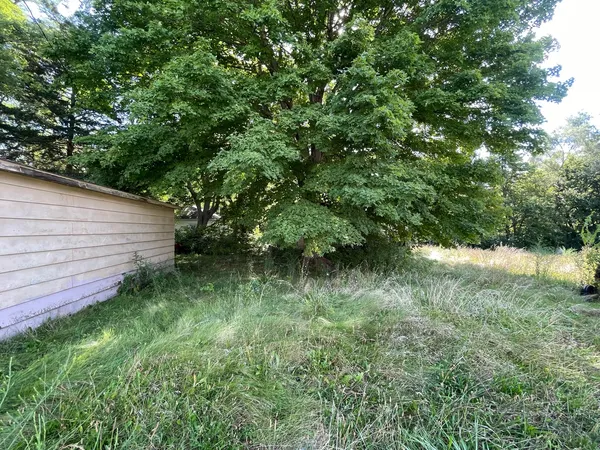 a backyard of a house with lots of green space and lake view