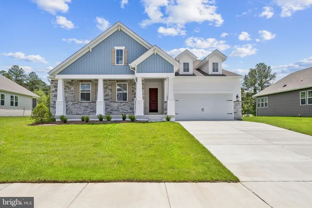 a front view of a house with a garden and yard