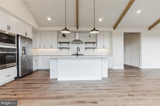 a kitchen with stainless steel appliances granite countertop a sink a stove and a refrigerator