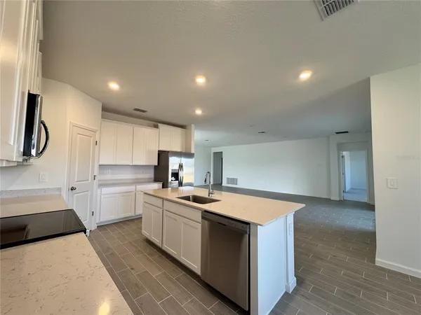 a kitchen with a stove sink and cabinets