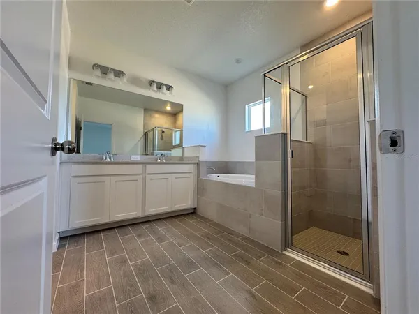 a bathroom with a double vanity sink mirror and shower