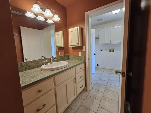 a bathroom with a granite countertop sink a mirror and a vanity