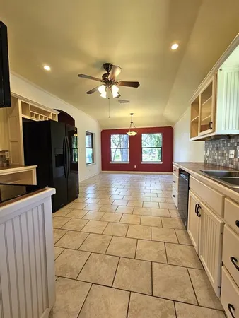 a large kitchen with stainless steel appliances a stove a sink and a refrigerator