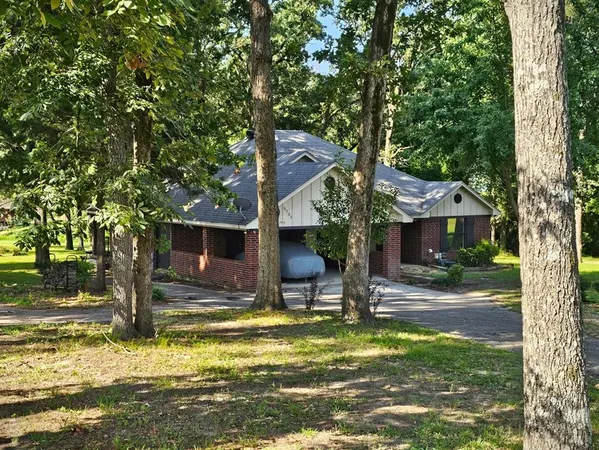a front view of a house with a yard tree and outdoor seating