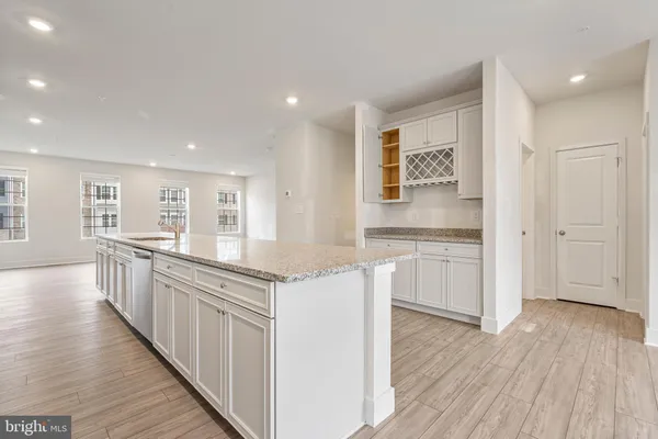 a kitchen with white cabinets and wooden floor