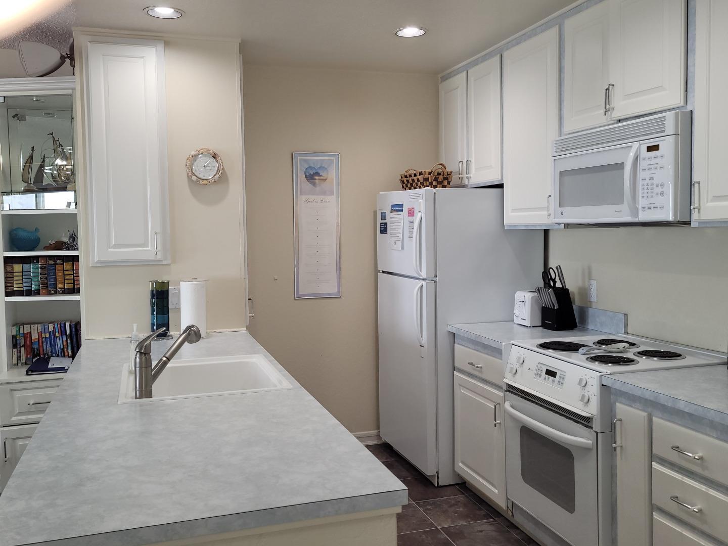 101 Shell Road, Unit 84 Watsonville, CA 95076 - Photo 21 of 40 a kitchen with refrigerator a stove a sink and cabinets