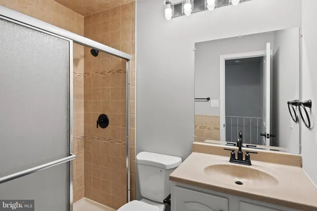 a bathroom with a sink a toilet a mirror and shower
