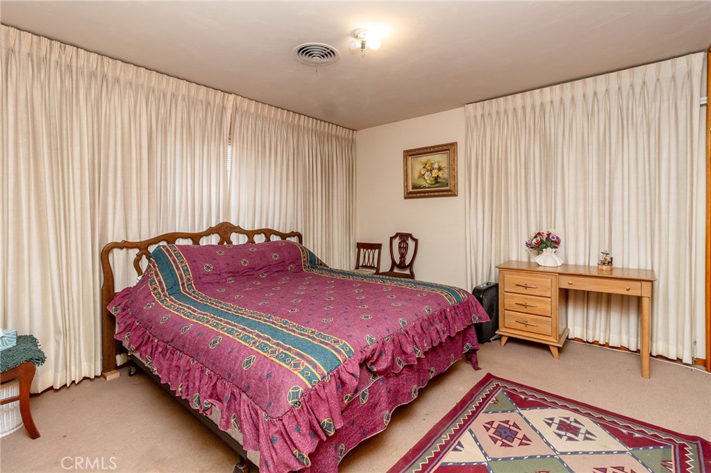 630 Acoma Street Needles, CA 92363 - Photo 15 of 60 a bedroom with bed and a chandelier