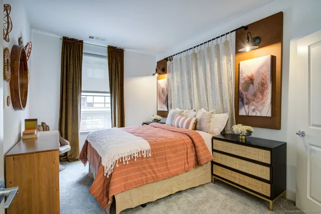 a bedroom with a bed lamp and a window