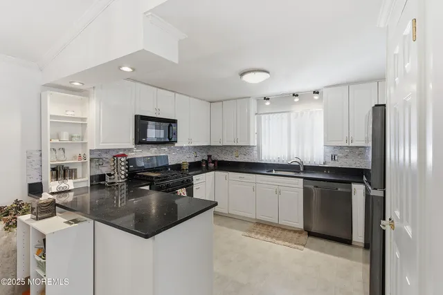 a kitchen with granite countertop a sink appliances and cabinets