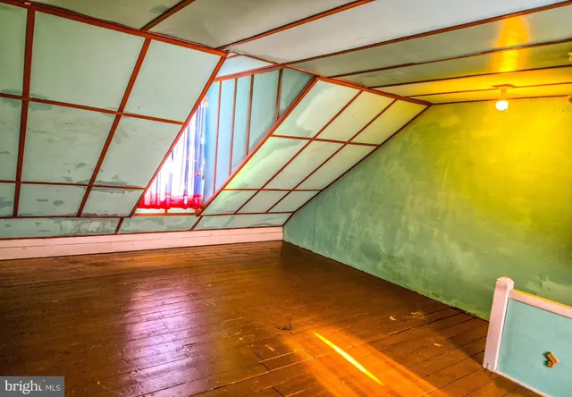 a view of an empty room with wooden floor and windows