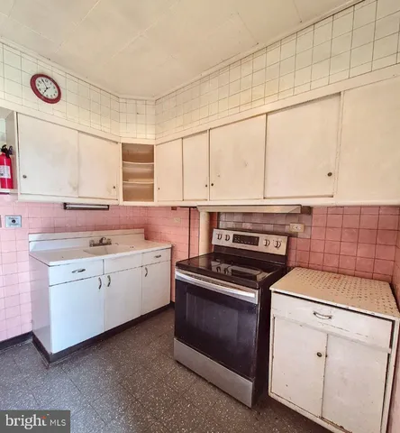 a kitchen with granite countertop a stove sink and cabinets