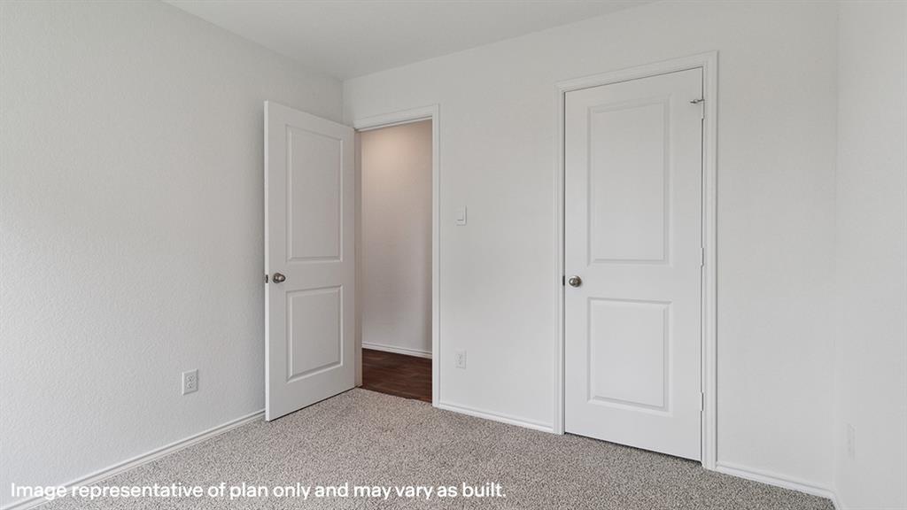 3522 Spring Time Street Forney, TX 75126 - Photo 21 of 27 Neutral wall finishes with textured white paint, two-panel interior doors with brushed nickel hardware, and grey carpeting