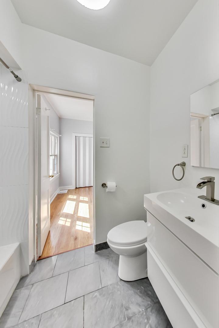4015 West Addison Street Chicago, IL 60641 - Photo 11 of 30 a bathroom with a sink a toilet and shower