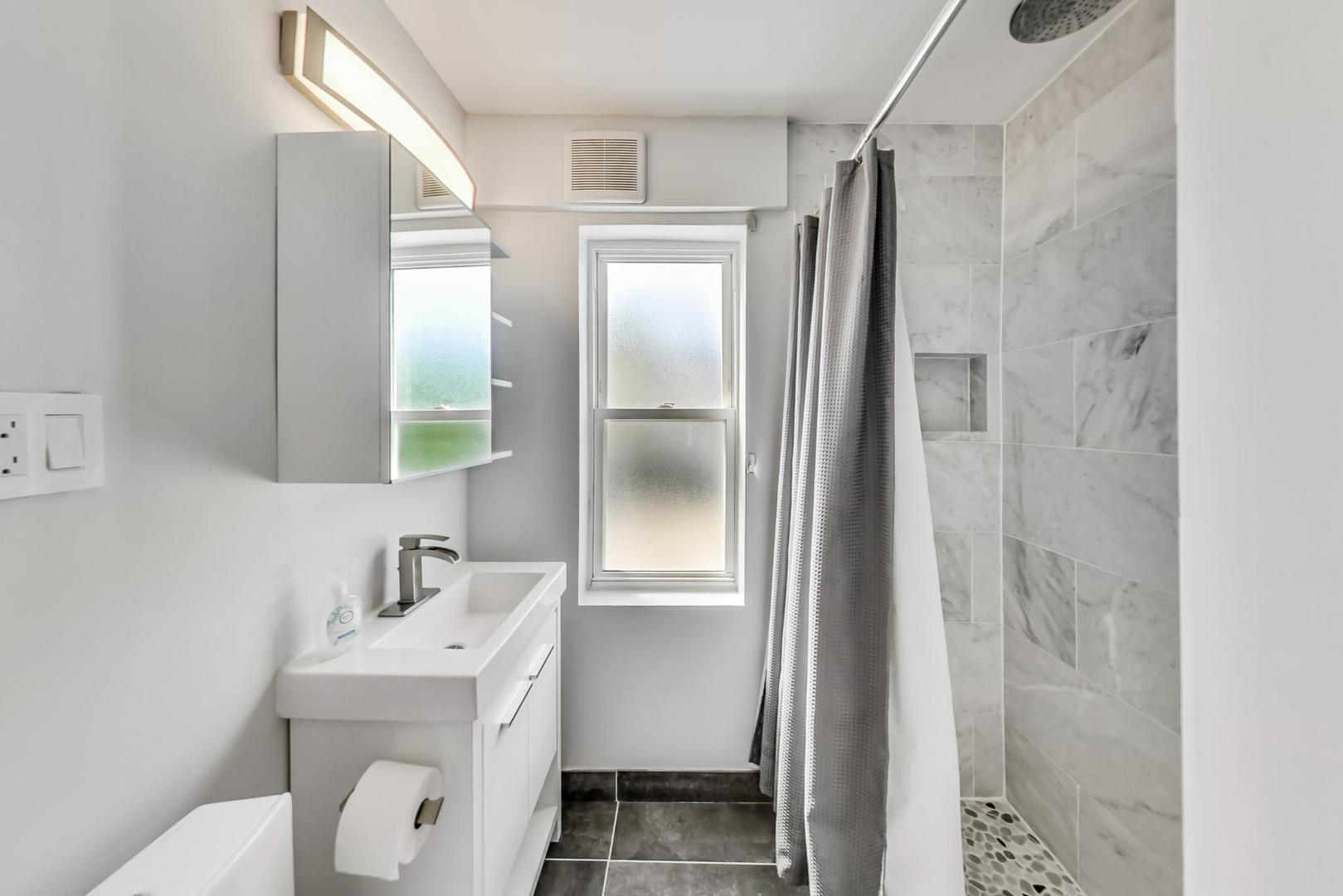 4015 West Addison Street Chicago, IL 60641 - Photo 17 of 30 a bathroom with a sink a toilet and shower