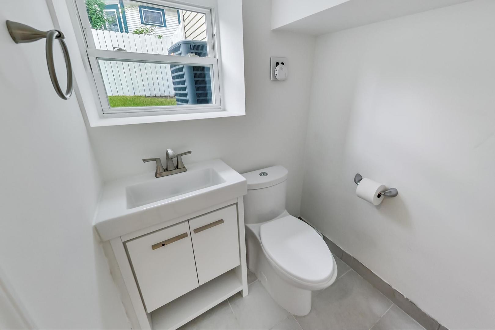 4015 West Addison Street Chicago, IL 60641 - Photo 21 of 30 a bathroom with a toilet sink and mirror