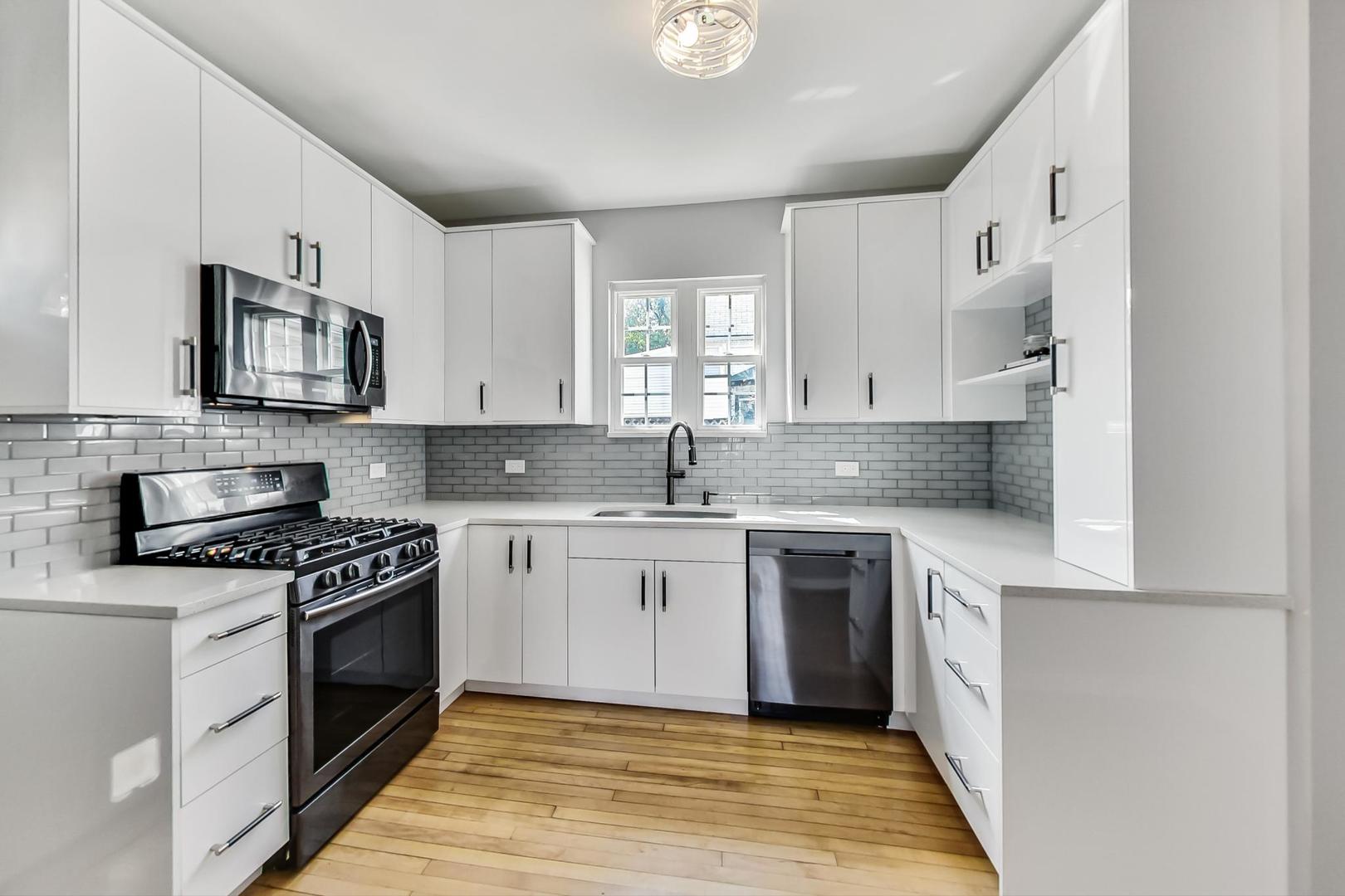 4015 West Addison Street Chicago, IL 60641 - Photo 6 of 30 a kitchen with stainless steel appliances granite countertop a stove a sink and a microwave