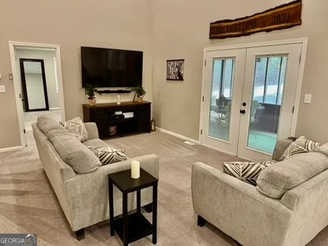 a living room with furniture and a view of kitchen