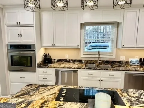 a kitchen with stainless steel appliances granite countertop a stove a sink dishwasher a refrigerator and cabinets with wooden floor