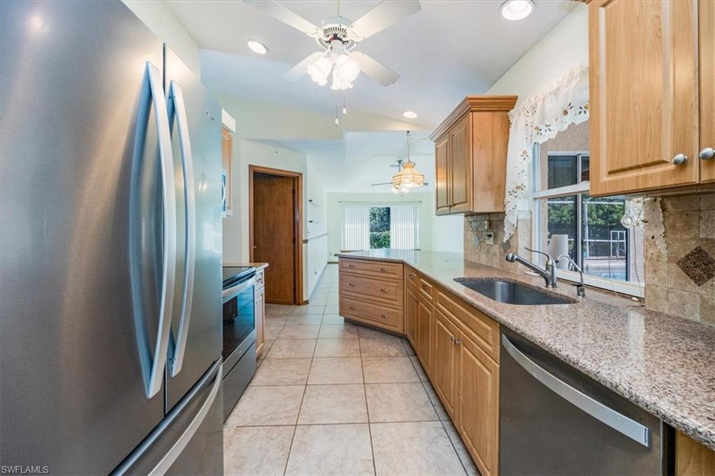 17520 Homewood Road Fort Myers, FL 33967 - Photo 13 of 24 a large kitchen with stainless steel appliances granite countertop a sink counter space cabinets and a large window