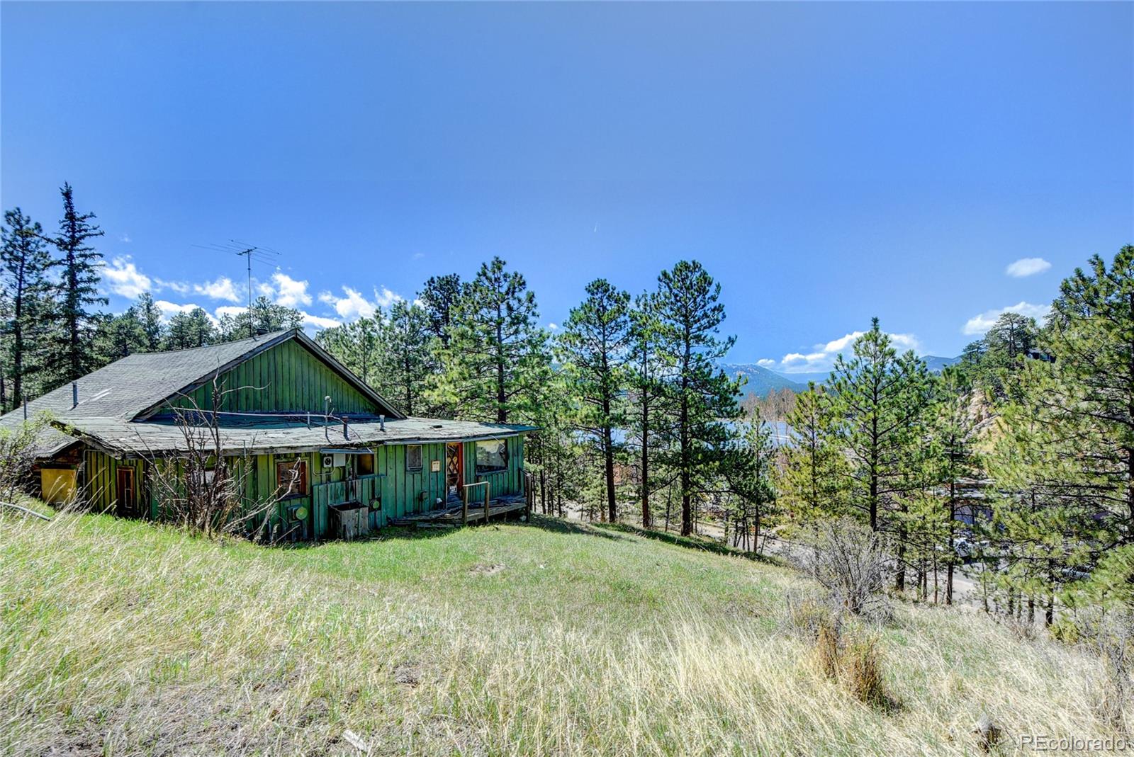 4690 Highway 73 Evergreen Co 80439 Evergreen, CO 80439 - Photo 16 of 34 a front view of a house with a yard