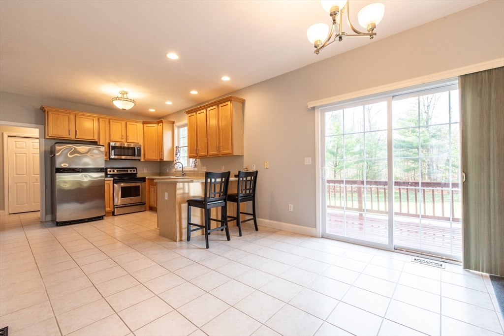 7 Buffy Road Bellingham, MA 02019 - Photo 8 of 34 a kitchen with granite countertop a refrigerator a stove top oven and cabinets