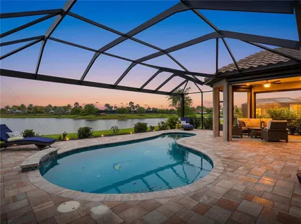 a view of a lake with a table and chairs next to a yard