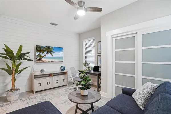 a living room with furniture potted plant and a mirror