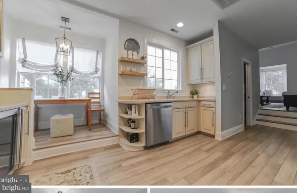 a kitchen with stainless steel appliances kitchen island granite countertop a sink cabinets and wooden floor