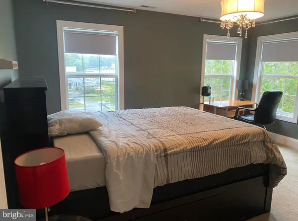 a bedroom with a bed dresser and a window