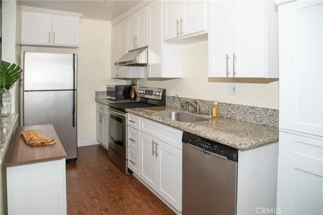 a kitchen with stainless steel appliances granite countertop a sink stove and refrigerator