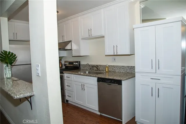 a kitchen with stainless steel appliances granite countertop a stove a sink and a refrigerator