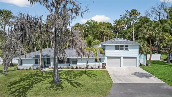 a front view of a house with a yard and tree s