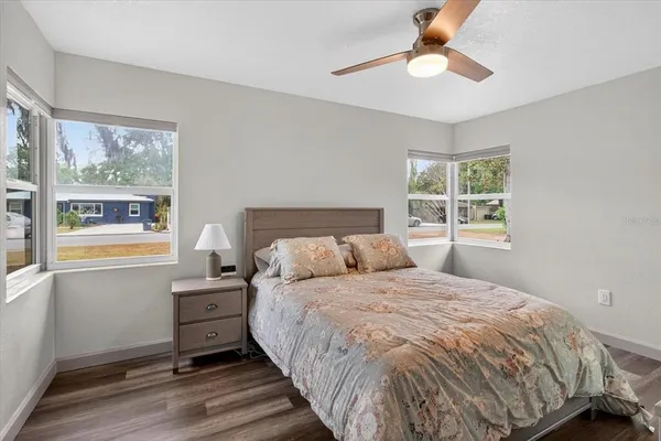 a dining room with furniture floor to ceiling window and wooden floor