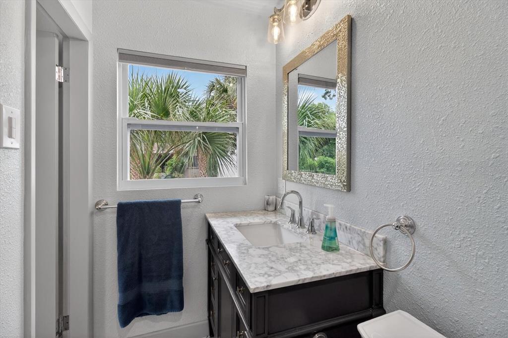 5539 Delaware Avenue New Port Richey, FL 34652 - Photo 28 of 95 a bathroom with a granite countertop sink a mirror and a window