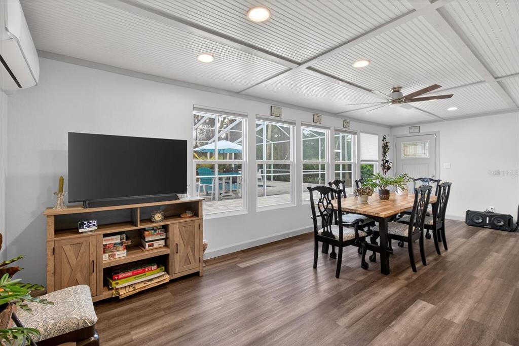 5539 Delaware Avenue New Port Richey, FL 34652 - Photo 41 of 95 a dining room with furniture floor to ceiling window and wooden floor