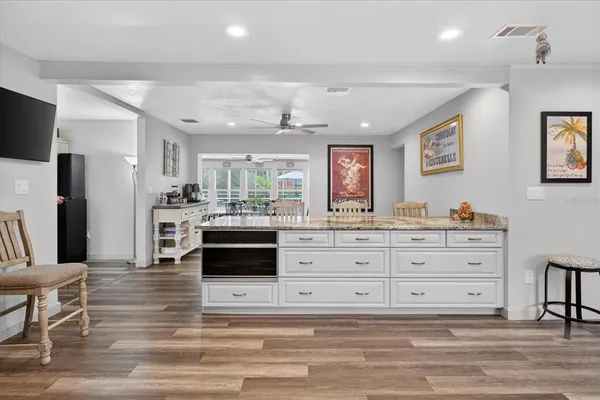a view of a white house with a big yard and large trees