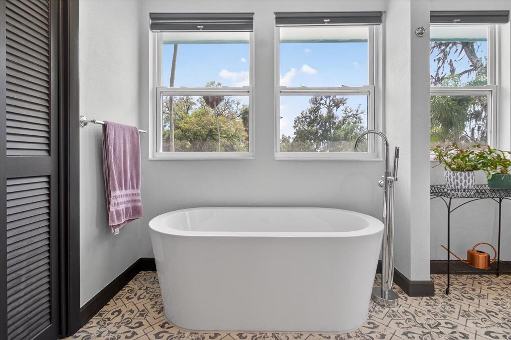 5539 Delaware Avenue New Port Richey, FL 34652 - Photo 58 of 95 a white bath tub sitting in a bathroom next to a window