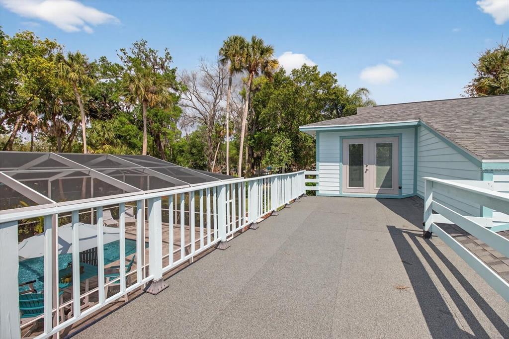 5539 Delaware Avenue New Port Richey, FL 34652 - Photo 63 of 95 a view of a balcony with chairs and floor to ceiling window and wooden fence