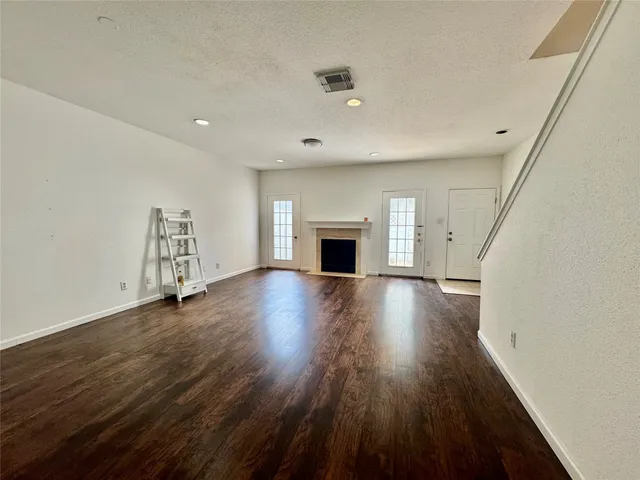 an empty room with wooden floor and fireplace