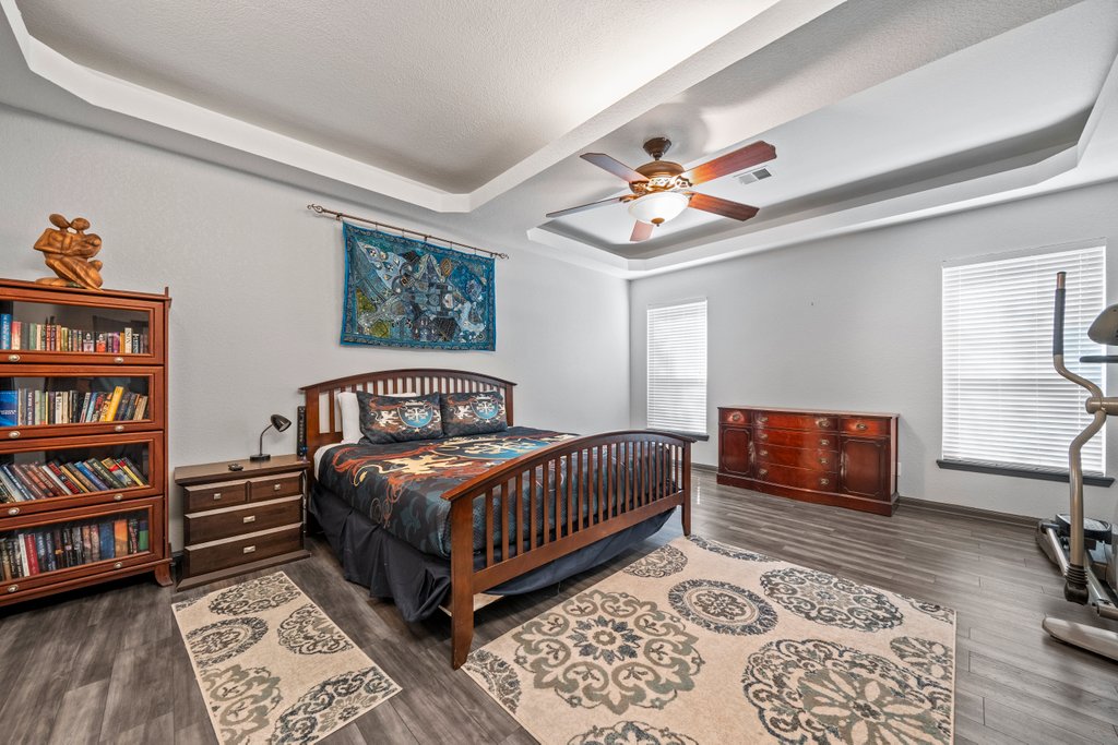 209 Lakeview Circle Spring Branch, TX 78070 - Photo 15 of 40 Bedroom with visible vents, baseboards, a ceiling fan, wood finished floors, and a tray ceiling