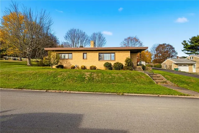 a front view of a house with a yard and trees