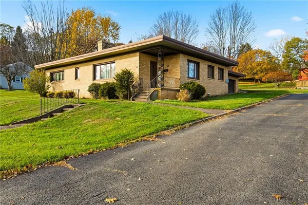a front view of house with yard and green space