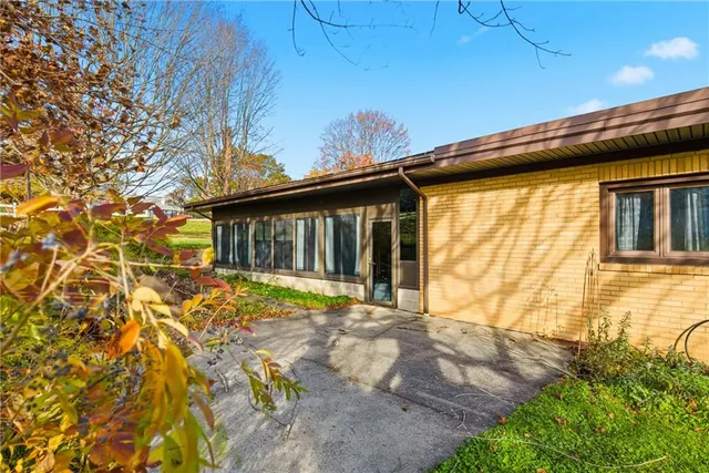 a view of a house with a backyard and a tree