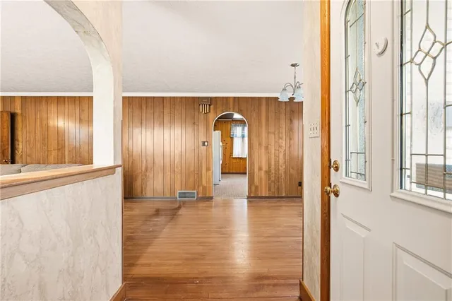 a view of a hallway with wooden floor and windows
